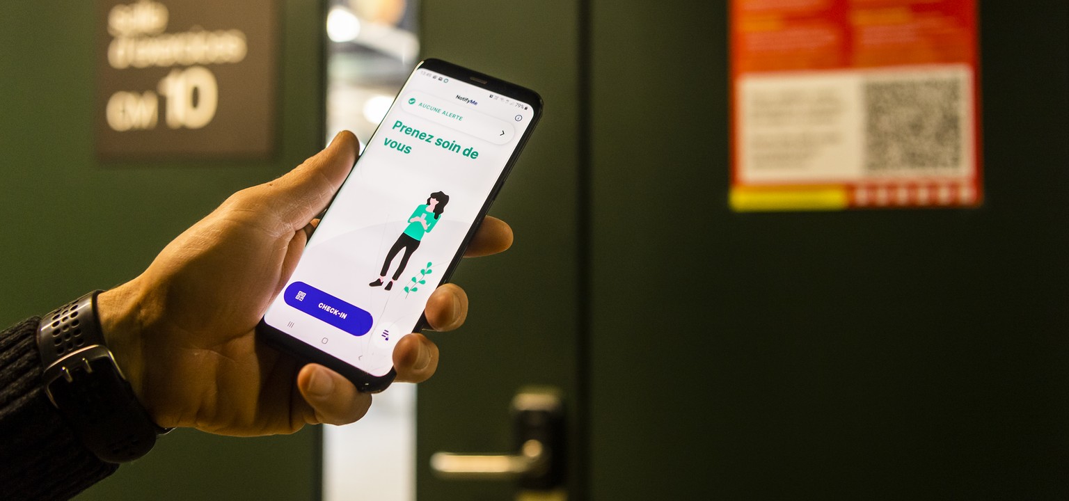 Une personne scanne avec son smartphone un QR Code grace a l&#039;application NotifyMe, une nouvelle app pour identifier des lieux a risque d?infection du Covid devant une classe du Campus de l&#039;E ...