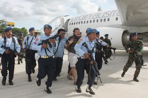 Grossaufgebot am Flughafen: Der betrunkene Australier wird abgeführt.