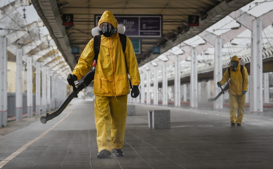 epa09531810 Worker from the Russian Ministry of Emergency Situations wearing protective suits conduct disinfecting works at Leningradsky Railway Station amid the ongoing coronavirus disease (COVID-19) ...