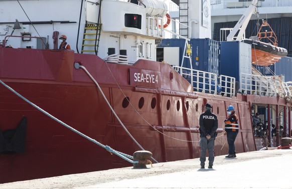 epa09216930 Italian police officers keep watch as the Sea Eye ship docks in Pozzallo, near Ragusa, Sicily Island, southern Italy, 21 May 2021. The Sea Eye ship docked in the port of Pozallo carrying s ...