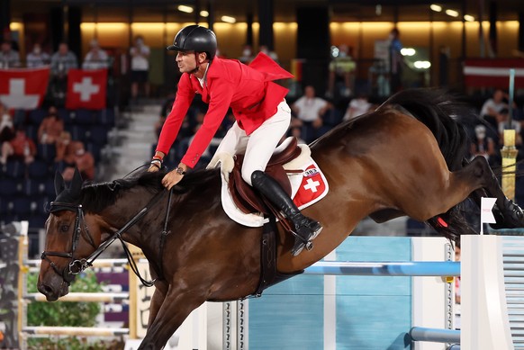 epa09401145 Steve Guerdat of Switzerland on Venard de Cerisy competes in the Jumping Team qualifier during the Equestrian events of the Tokyo 2020 Olympic Games at the Baji Koen Equestrian Park in Set ...