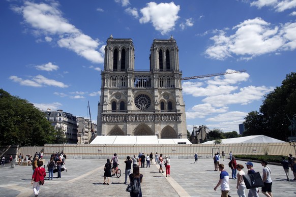 FILE - I this May 31, 2020 file photo, people walk on the forecourt of Notre Dame&#039;s Cathedral, in Paris. France&#039;s Notre Dame Cathedral is finally stable and secure enough for artisans to sta ...