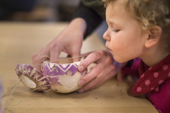 With the help of her mother, a girl carves a turnip for the so called &quot;Raebelichetliumzug&quot; (verbatim: turnip light procession), a Swiss tradition, captured at the community centre Loogarten  ...