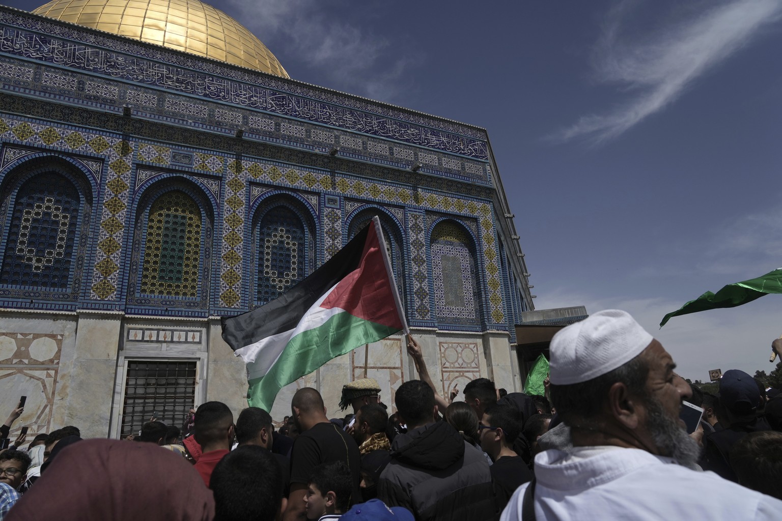 A worshipper waves the Palestinian flag after Friday prayers during the Muslim holy month of Ramadan, hours after Israeli police clashed with protesters at the Al Aqsa Mosque compound, in Jerusalem&#0 ...