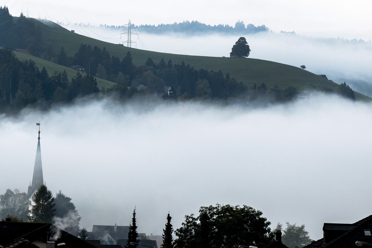 Der Kirchturm zeichnet sich durch den Nebel, am Montag, 16. Oktober 2023, in Wald. (KEYSTONE/Peter Schneider)