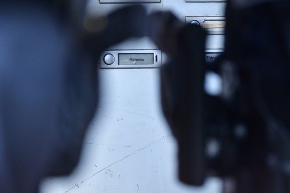 epa08824759 The name Remmo, related to a Berlin Arabian clan family, can be seen between gun holsters of policemen on a doorbell sign during a raid linked to the Green Vault (Gruenes Gewoelbe) burglar ...