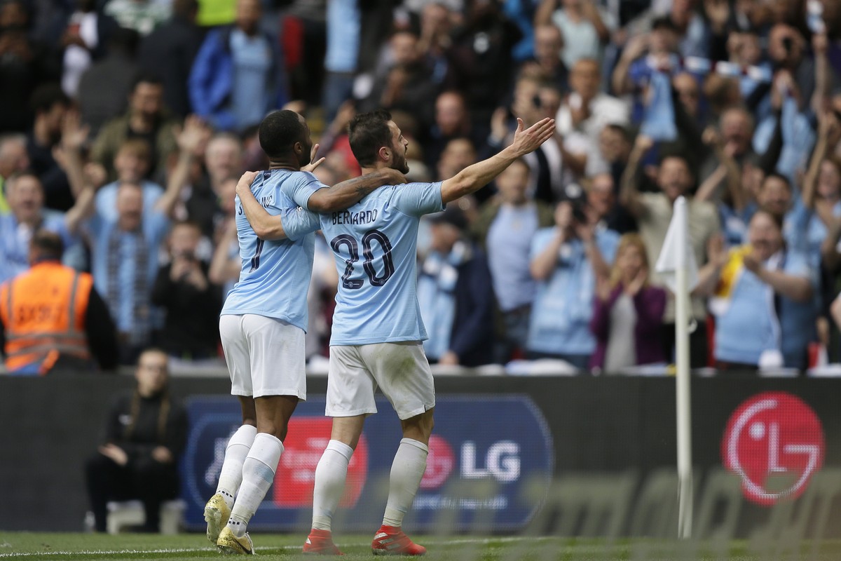 Manchester City's Raheem Sterling, left, celebrates after scoring his side's fifth goal with his teammate Manchester City's Bernardo Silva during the English FA Cup Final soccer match b ...
