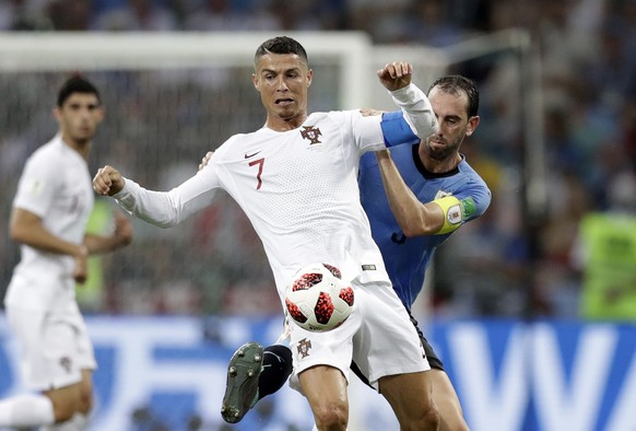 Portugal&#039;s Cristiano Ronaldo, front, is challenged by Uruguay&#039;s Diego Godin during the round of 16 match between Uruguay and Portugal at the 2018 soccer World Cup at the Fisht Stadium in Soc ...