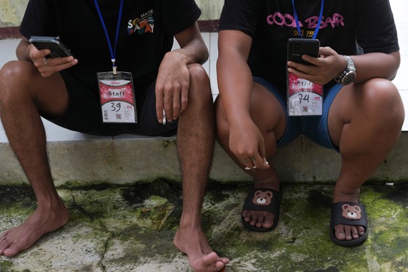 People rescued from a scam center in Myanmar use their mobile phones at a temporary shelter in Jakarta, Indonesia, Tuesday, March 4, 2025. (AP Photo/Achmad Ibrahim)
Thailand Myanmar Scammers Trapped