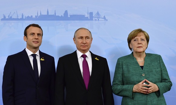 German Chancellor Angela Merkel, right, poses with French President Emmanuel Macron, left, and Russia&#039;s President Vladimir Putin prior to a meeting during the G20 summit in Hamburg, Germany, Satu ...