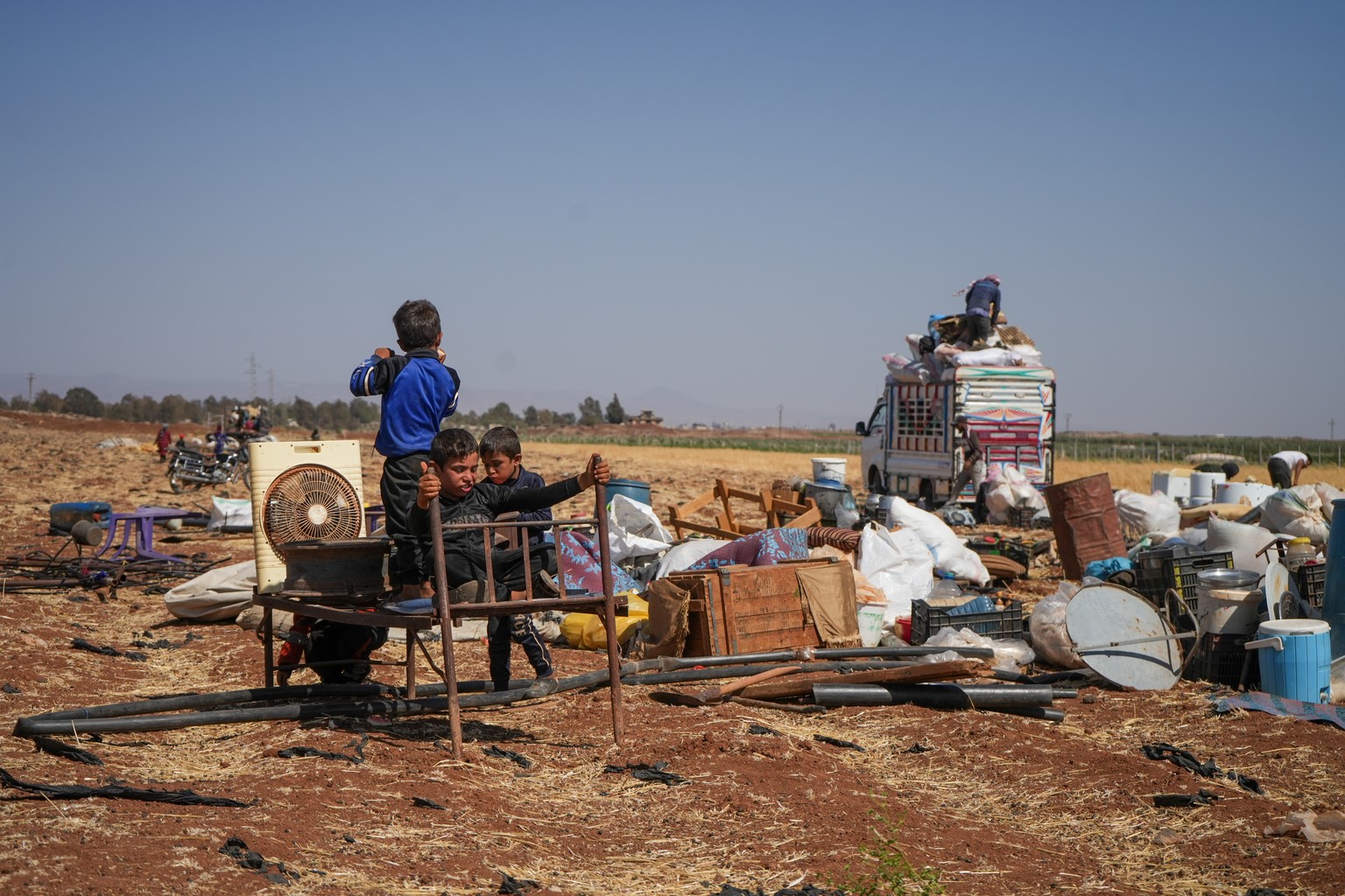 KEYPIX - epa12243463 Displaced Arab Bedouin children play as they rest in the open with their belongings near the town of Busra al-Harir, in the countryside of the Daraa Governorate, after fleeing As  ...