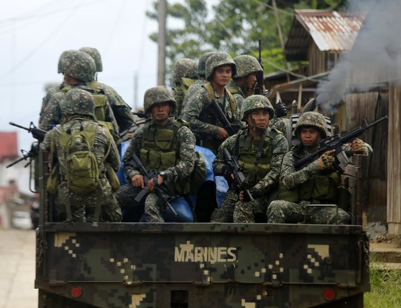 epa06005006 Filipino government troops on a truck maneuver at a deserted street as fighting between Islamist militants and government forces continues in Marawi City, Mindanao Island, southern Philipp ...