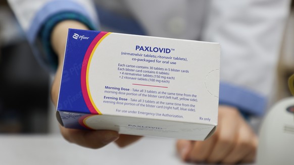 epa09775282 A pharmacist displays a case of Paxlovid, a COVID-19 treatment pills developed by Pfizer Inc., at a drugstore in Seoul, South Korea, 21 February 2022. The age restriction on the administra ...