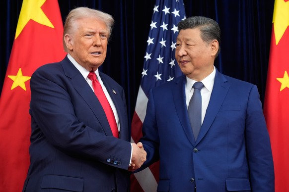 FILE - President Donald Trump, left, and Chinese President Xi Jinping shake hands before their meeting at Gimhae International Airport in Busan, South Korea, Oct. 30, 2025. (AP Photo/Mark Schiefelbein ...