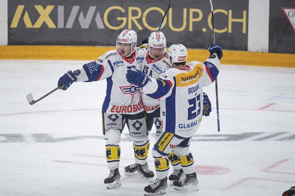 From left, Kloten&#039;s player Arttu Routsalainen, Kloten&#039;s player Miro Aaltonen and Jordann Bougro, celebrate the 4-5 goal, during the preliminary round game of the National League 2022/23 betw ...