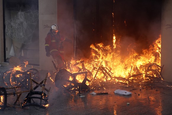 epa07442856 A fireman tries to extinguish a fire at the burning luxury store Longchamps on the Champs Elysees during the &#039;Act XVIII&#039; demonstration (the 18th consecutive national protest on a ...