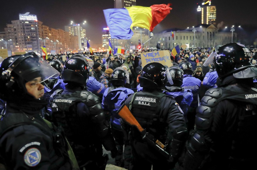Romanian riot police protect the government building from crowds before minor clashes erupted during a protest in Bucharest, Romania, Wednesday, Feb. 1, 2017. Brief clashes broke out between protester ...