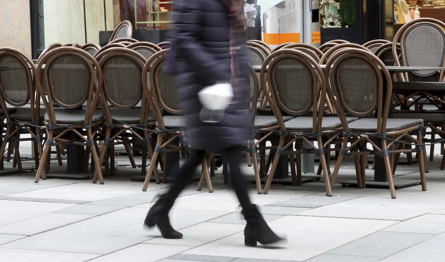 A person walks past a closed bar in downtown in Vienna, Austria, Monday, March 22, 2021. The Austrian government is considering on further measures to contain the coronavirus pandemic. (AP Photo/Ronal ...