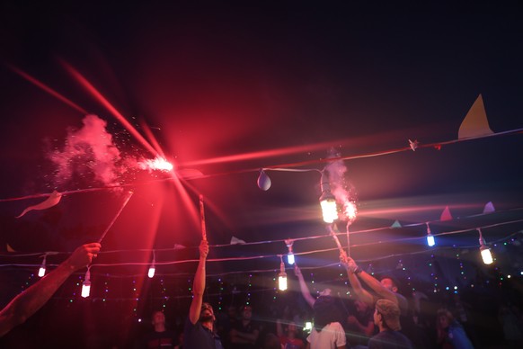 epa06812037 Members of the Molham Volunteering Team and children play with fireworks during Eid al-Fitr celebrations in a garden in Idlib, Syria, 15 June 2018. Muslims around the world are celebrating ...