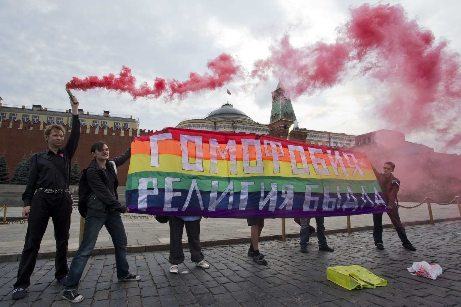 FILE - Gay rights activists hold a banner reading &quot;Homophobia - the religion of bullies&quot; during their action in protest at homophobia, on Red Square in Moscow, Russia, on July 14, 2013. Russ ...