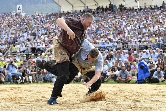 epa06166961 Swiss alpine wrestler Christian Stucki (L) fights with Curdin Orlik in the final round of the wrestling competition called Schwinget as part of the Unspunnenfest 2017 in Interlaken, Switze ...