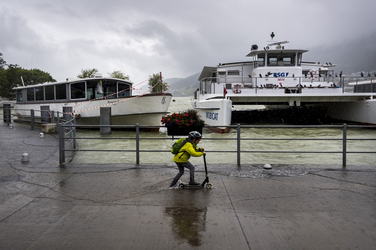 Un enfant roule avec sa trottinette dans l'eau du lac qui deborde dans le port lors de la montee de l'eau du lac de Bienne suite aux fortes precipitations des derniers jours le jeudi 15 juil ...