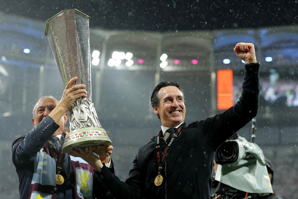 Aston Villa's head coach Unai Emery, right, holds the winner's trophy after the Europa League final soccer match between Freiburg and Aston Villa in Istanbul, Turkey, Thursday, May 21, 2026. ...