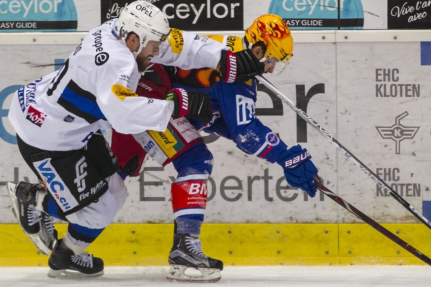 HC Fribourg-Gotteron Verteidiger Jonas Holos, links, gegen EHC Kloten Stuermer Vincent Praplan waehrend dem Eishockey-Meisterschaftsspiel der National League zwischen dem EHC Kloten und dem HC Fribour ...