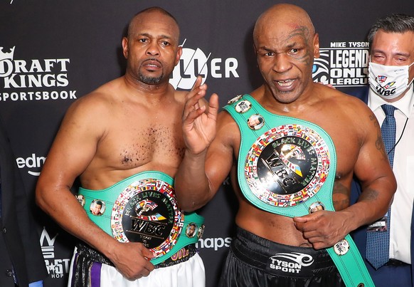 epa08850189 (L-R) Roy Jones Jr. and Mike Tyson celebrate their split draw after the Mike Tyson vs Roy Jones Jr. fight at the Staples Center in Los Angeles, California, USA, 28 November 2020. EPA/JOE S ...