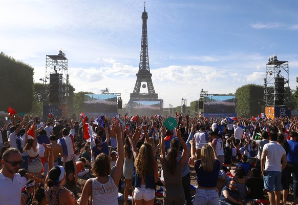 Supporters wait in front of giant screens, with the Eiffel Tower in background, in the Paris fan zone, before the Euro 2016 final soccer match between Portugal and France, Sunday, July 10, 2016 in Par ...