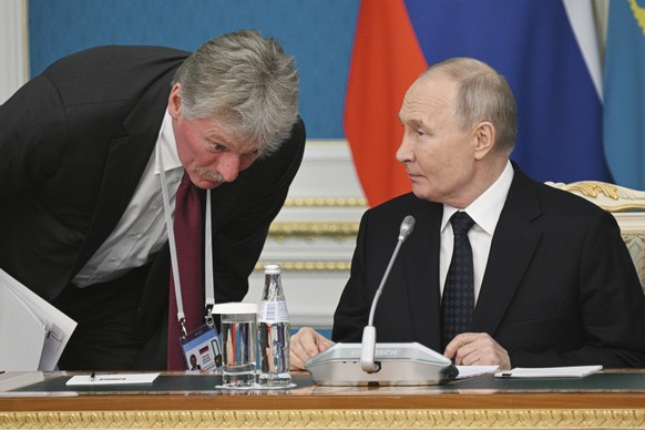 Kremlin spokesman Dmitry Peskov, left, listens to Russian President Vladimir Putin before a signing ceremony at the Akorda presidential residence in Astana, Kazakhstan, Wednesday, Nov. 27, 2024. (Rami ...