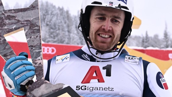 epa09702119 Winner Dave Ryding of Britain celebrates with his trophy after the men&#039;s Slalom race of the FIS Alpine Skiing World Cup event in Kitzbuehel, Austria, 22 January 2022. EPA/CHRISTIAN BR ...