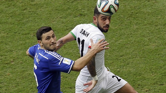 Bosnia defender Sead Kolasinac, left, battles Iran midfielder Ashkan Dejagah for the ball during the second half of a group F World Cup soccer match at the Arena Fonte Nova in Salvador, Brazil, Wednes ...