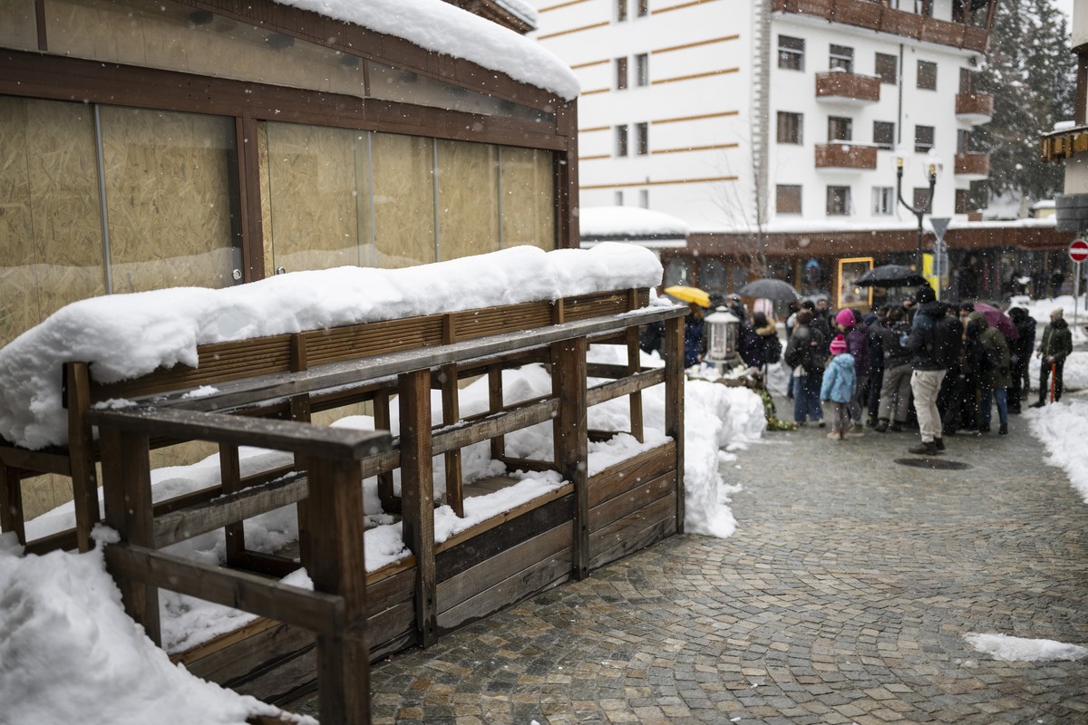 Mourners gather to a ceremony in front of the "Le Constellation" bar, left, in Crans-Montana to commemorate the victims of the deadly fire at the "Le Constellation", in Crans-Monta ...