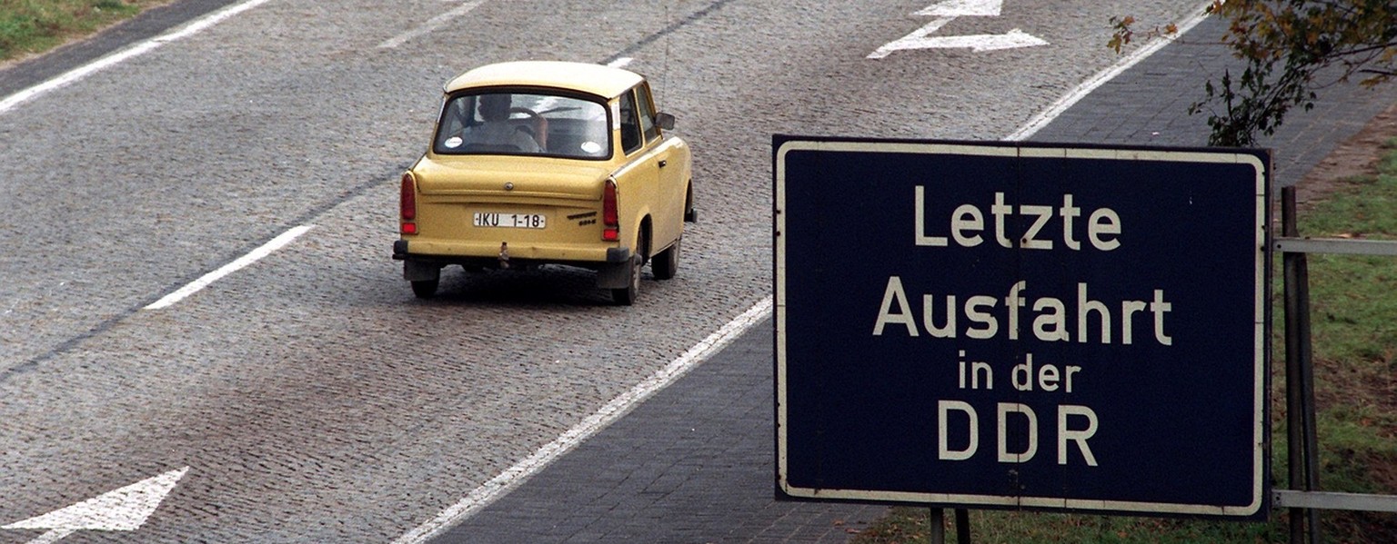 An East German Trabant (&quot;Trabi&quot;) car passes a road sign with the inscription &quot;Last Exit on East German territory&quot; on October 2, 1990 on a highway in Frankfurt/Oder near the Polish  ...