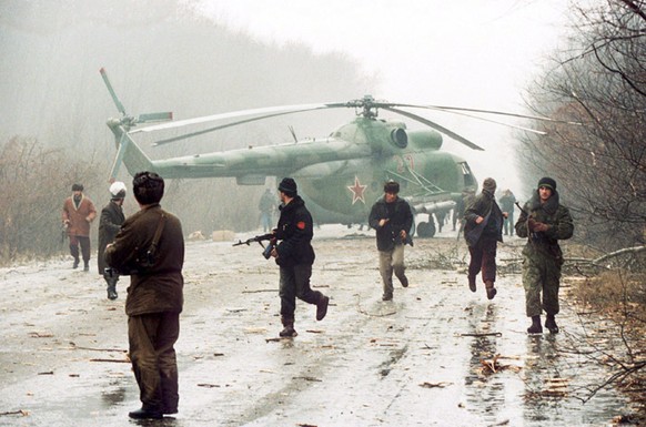 Tschetschenen vor einem zur Notlandung gezwungenen russischen Helikopter&nbsp;Mil Mi-8.&nbsp;