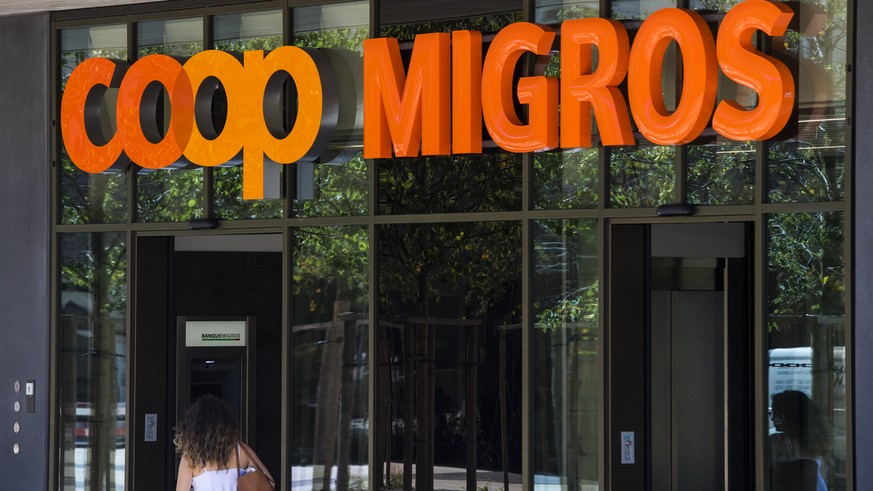 Le logo de la Coop et le logo de la Migros sont photographies cote a cote sur un batiment commercial commun ce mardi 23 aout 2016 sur la place de la Sallaz a Lausanne. (KEYSTONE/Jean-Christophe Bott)