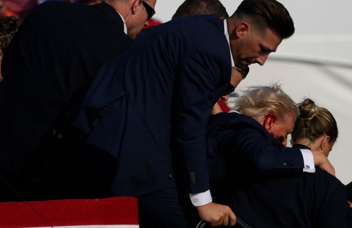 BUTLER, PENNSYLVANIA - JULY 13: Secret Service agents surround Republican presidential candidate former President Donald Trump onstage after he was injured at a rally on July 13, 2024 in Butler, Penns ...