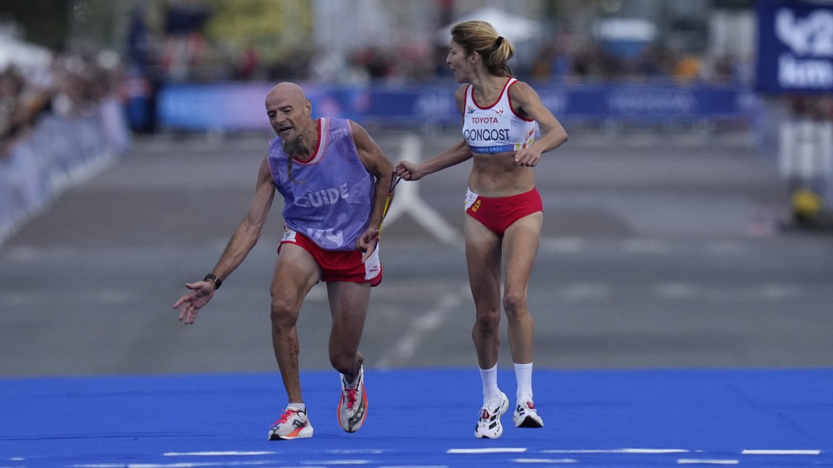 ADDITION ELENA CONGOST WAS DISQUALIFIED FOR LETTING GO OF THE ROPE TO HELP HER GUIDE - Spain's Elena Congost, right, arrives in third position in the women's marathon T12 at the 2024 Paralym ...