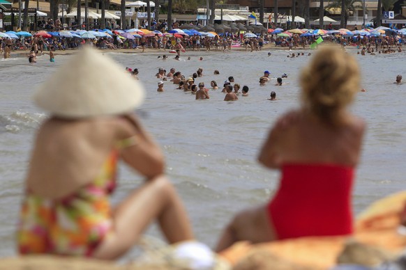 epa11508638 Beachgoers cool of in the water on a sunny day in Torrevieja, Alicante, Spain, 30 July 2024. Authorities issued an orange heat alert for the Valencian Community, with temperatures reaching ...