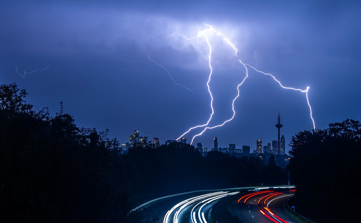 ARCHIV - 12.09.2023, Hessen, Frankfurt/Main: Blitze sind w�hrend eines Gewitters �ber der Skyline von Frankfurt am Main und der Autobahn A661 zu sehen. (zu dpa: �Wetterdienst warnt vor Gewittern, Star ...