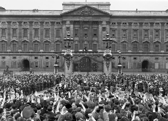 FILE - A vast crowd assembled in front of Buckingham Palace, London, on V-E Day, May 8, 1945, cheers the Royal Family as they come out on the balcony, centre, minutes after the official announcement o ...