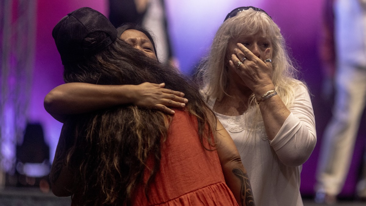 Attendees embrace during a church service at King's Cathedral in Kahului on the island of Maui, Hawaii Sunday, Aug. 13, 2023. The church has been converted into an emergency shelter and destructi ...