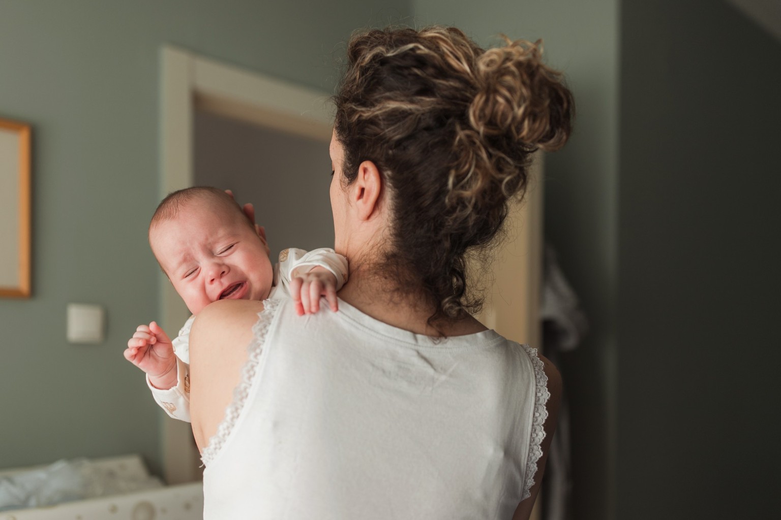 Newborn baby crying when being held in mother&#039;s arms