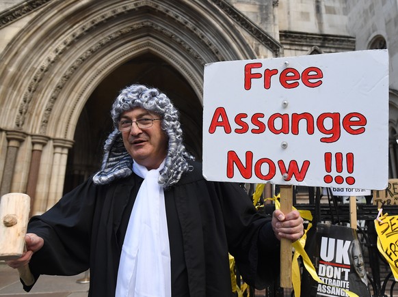 epa09550320 A Julian Assange supporter outside the High Court in London, Britain, 28 October 2021. Julian Assange is facing extradition to the United States over the publication of secrets relating to ...
