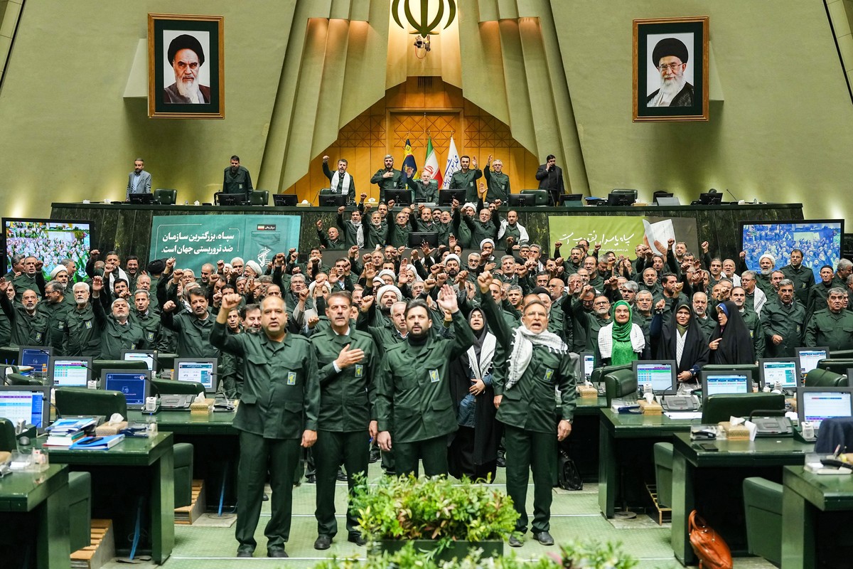 In this handout photo released by the Islamic Consultative Assembly News Agency (ICANA) Iranian lawmakers chant slogans as they wear the Revolutionary Guard's uniform in a session of parliament,  ...