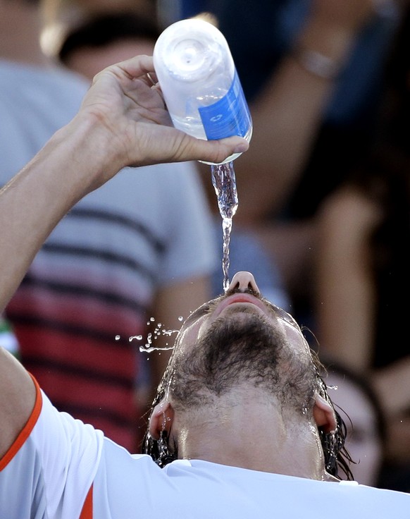 Feliciano Lopez of Spain pours water over himself during a break in his second round game against Guido Pella of Argentina at the Australian Open tennis championships in Melbourne, Australia, Thursday, Jan. 21, 2016.(AP Photo/Aaron Favila)