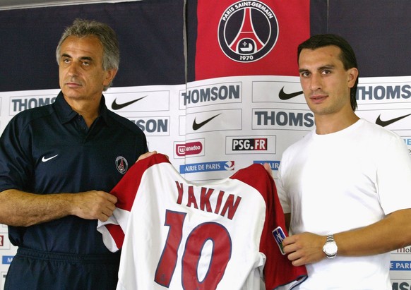 Midfielder Hakan Yakin of Switzerland, right, and Paris Saint Germain new coach Vahid Halilhodzic present Yakim&#039;s new PSG jersey during a press conference held in Saint Germain en Laye, west of P ...