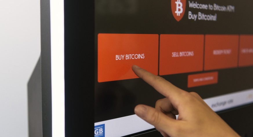 ZUM BEZUG VON BITCOINS AM BANKOMATEN STELLEN WIR IHNEN HEUTE, DIENSTAG, 22. AUGUST 2017, FOLGENDES NEUES BILDMATERIAL ZUR VERFUEGUNG --- [Symbolic Image, Staged Picture] A person buys bitcoins from a  ...