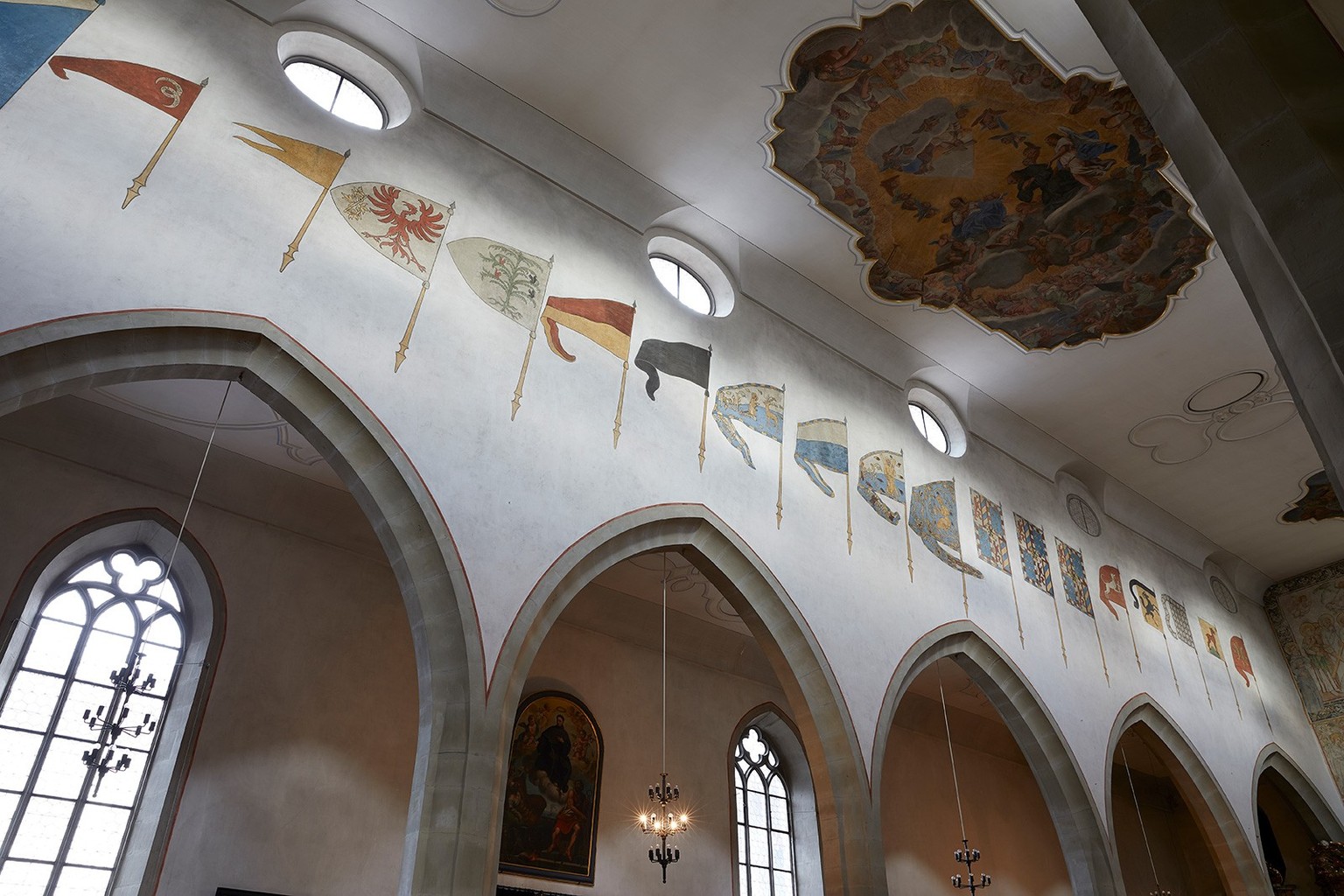 Blick in die Franziskanerkirche von Luzern, linke Wand des Mittelschiffs mit den ursprünglich originalen, nach 1622 aufgemalten erbeuteten Fahnen aus siegreichen eidgenössischen Schlachten.